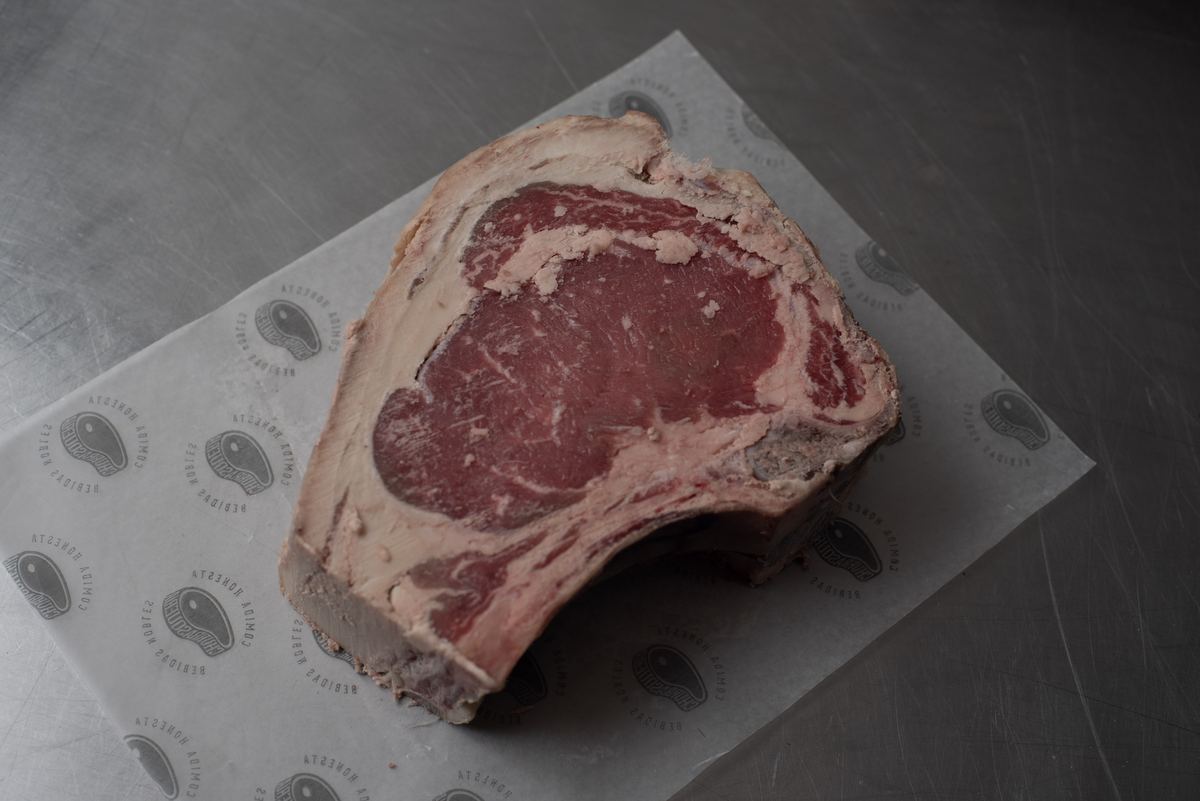 Ojo de bife crudo sobre el papel de la carnicería, antes de ir a la parrilla