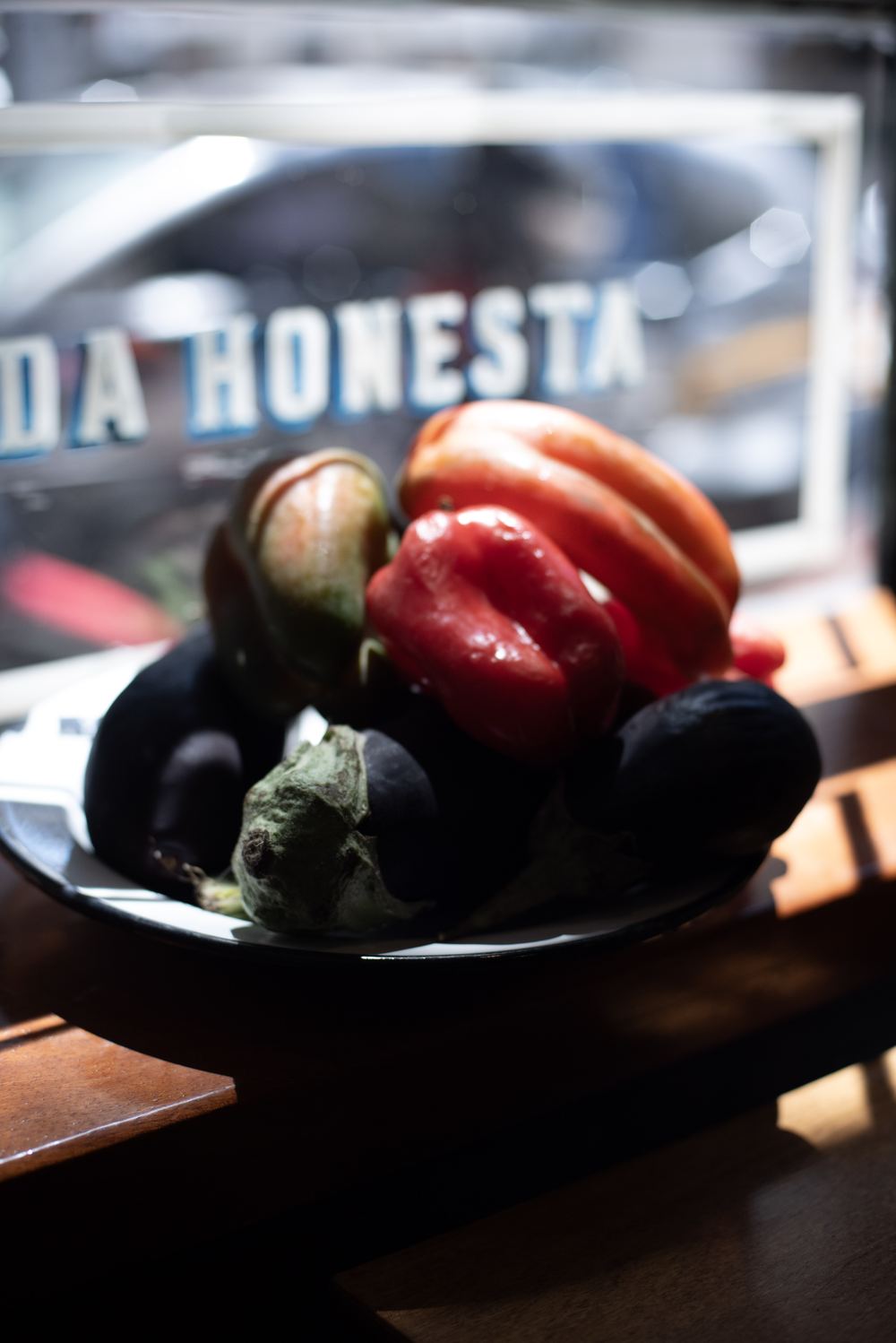 Fuente de verduras de estación frente a la vidriera con la leyenda comida honesta